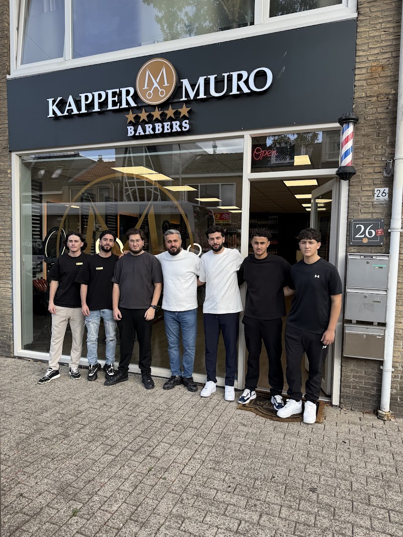 De gevel van Kapper Muro met het team ervoor